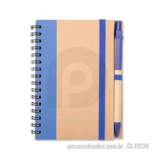 Bloco ecológico personalizado - Caderno com capa em papel kraft, encadernação Wire-O, elástico para fechamento, suporte para canetas lateral elástico e aproximadamente 70 folhas pautadas em papel offset na cor marfim. Acompanha uma caneta em papelão com ponteira, clipe e acionamento por clique em plástico e carga esferográfica azul de 1,0mm.