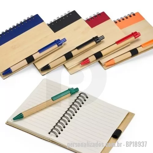 Bloco personalizado - Caderno com capa em casca de bambu, faixa decorativa colorida na vertical, porta-caneta em elástico, encadernação Wire-O e cerca de 70 folhas pautadas. Acompanha uma caneta esferográfica de carga azul de 0,8 mm com corpo em papelão e clip, acionamento em clique e ponteira em plástico.  Largura :  10,5 cm  Comprimento :  13,5 cm  Espessura :  1 cm