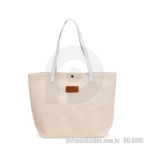 Bolsa multiuso personalizada - Bolsa em palha trançada com fechamento em botão metálico. Revestimento interno em algodão, bolso com zíper, alças e plaqueta em couro sintético.