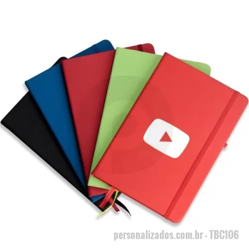 Caderneta personalizada - Caderneta tipo moleskine emborrachado com porta caneta elástico em nylon, marcador de página em cetim e fita elástica de nylon para fechar. Contém aproximadamente 80 folhas pardas pautadas.