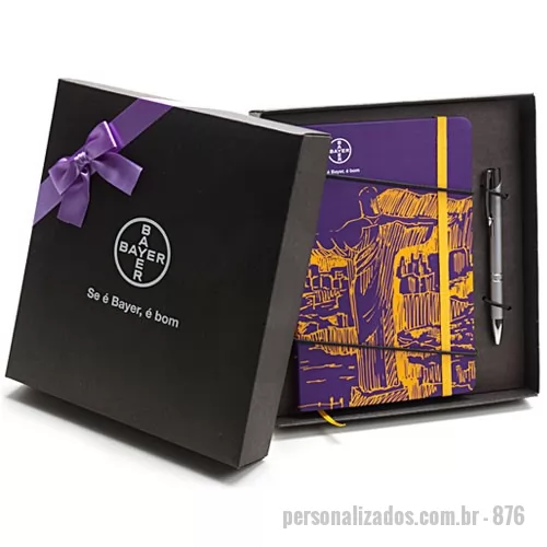 Caderneta personalizada - Kit composto por Bloco de capa dura revestido com couchê 150 g 4x0 cor com laminação fosca frente. Guardas em color plus 180 g 0x0 cor. Miolo sem pauta com 80 folhas em papel polém 70 g 0x0 cor, costurado, cantos arredondados, fechamento com elástico e marcador de cetim. Kit acondicionado em caixa de papel kraft preto 300 g 21 x 23 x 4 cm. A personalização é a 1 cor na tampa da caixa e à laser na caneta metálica. Laço de cetim não incluso, é opcional.