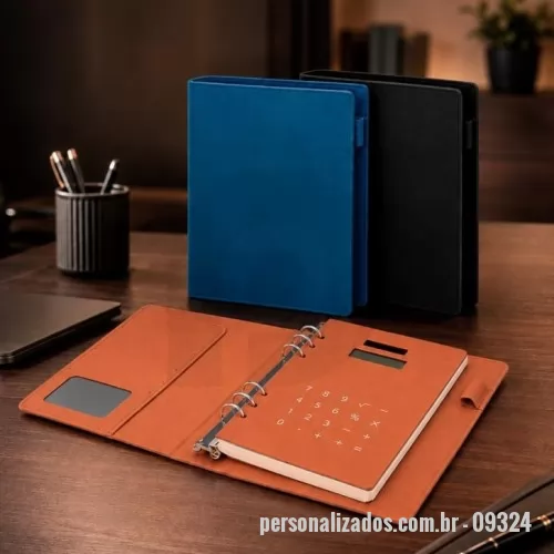 Caderno Capa Dura personalizado - Caderno tipo fichário com capa dura em poliuretano (PU). Possui seis argolas metálicas, aba interna com compartimento para três cartões e visor plástico transparente para documento, suporte lateral para caneta e calculadora alimentada por energia solar com teclas touch e estrutura em PU. Apresenta cerca de 96 folhas tamanho A5 marfim pautadas de 75 g/m².