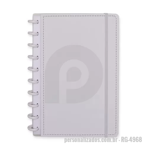 Caderno personalizado - Caderno capa dura em papelão, com elástico para fechamento e encadernação em discos plásticos reposicionáveis, que permitem acrescentar ou remover folhas compatíveis com facilidade. Conta com aproximadamente 80 folhas brancas pautadas.
