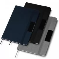 Caderno de anotações com placa de metal para personalização, fechamento em fita elástica, capa dura em material reciclável, miolo com 80 folhas pautadas na cor bege. NÃO ACOMPANHA CANETA.