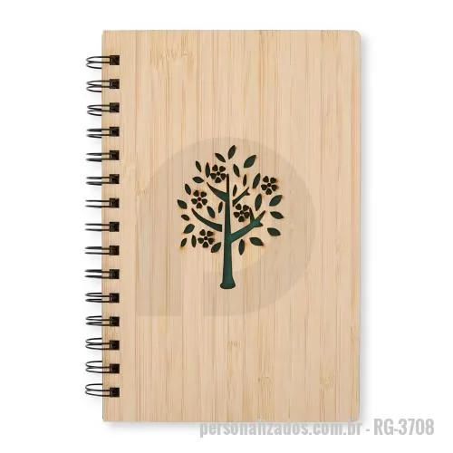 Caderno reciclado personalizado - Com design sustentável, este caderno em bambu conta com aproximadamente 69 folhas brancas pautadas. Sua capa rígida com arte vazada ganha destaque com a folha de guarda verde, enquanto o espiral metálico garante resistência e praticidade durante o us