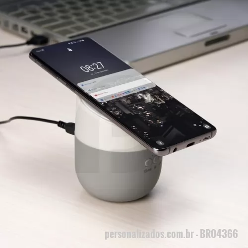 Caixa de Som com Bluetooth personalizada - Caixinha de Som bluetooth com carregador por indução. Produzido em material plástico, a caixinha possui antiderrapantes emborrachados na parte inferior, e na área de indução. Para desfrutar do carregamento por indução (sem fio) é fundamental que o celular possua a tecnologia QI – desta maneira é possível carregar o celular posicionando-o sob carregador, sendo necessário apenas conectar o carregador à uma fonte de energia (USB ou diretamente na tomada). A caixinha executa nos modos bluetooth e cartão TF (microSD) Acompanha cabo USB.