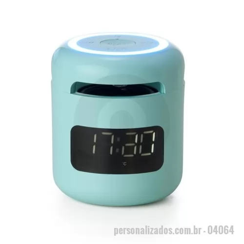 Caixa de som personalizada - Caixa de som multimídia com relógio despertador. Produzida em plástico e com borrachas antiderrapantes na área inferior, a caixa de som tem bateria de longa duração, display de LED na área frontal, e anel de led brilhante na parte superior. A caixa de som executa nos modos bluetooth, rádio FM...