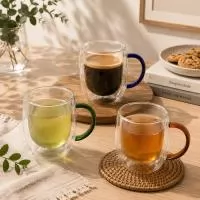 Caneca de vidro borossilicato com capacidade de até 350ml e estrutura de parede dupla, desenvolvida para reduzir a transferência de temperatura para a superfície externa durante o uso. Seu corpo transparente evidencia a cor e a apresentação das bebid
