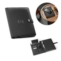 Pasta A5 em 300D rPET com carregador wireless embutido. A bateria tem capacidade para 5.000 mAh, potência de 10W, entrada/saída 5V/2.1A e cabo USB tipo C para carregar a bateria. A pasta contém no seu interior um bolso para smartphone até 6.5