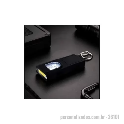 Chaveiro lanterna personalizado - Chaveiro lanterna recarregável com estrutura em plástico. Possui duas fontes de iluminação em LED, com quatro níveis de intensidade em luz branca e modo piscante nas cores azul e vermelha, acionados por botão lateral. Conta ainda com base magnética para fixação em superfícies metálicas, entrada USB-C para carregamento e mosquetão metálico fixo. Acompanha cabo USB-C.