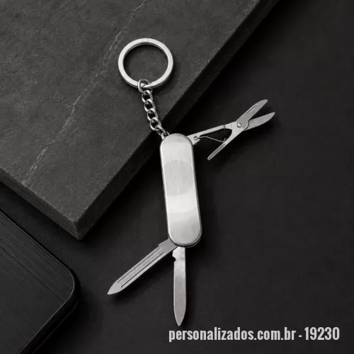 Chaveiro personalizado - Canivete com estrutura em aço inox e três funções diferentes: lâmina de corte, lixa de unha e uma mini tesoura, além de argola metálica.