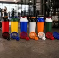 Coqueteleira produzida em polipropileno, de fabricação própria, com estrutura leve, resistente e design bicolor. Conta com tampa prática com bocal e alça acoplada, facilitando o transporte e o consumo em diferentes momentos da rotina, acompanhada de 