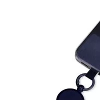 Cordão com alça ajustável para celular feito em poliéster. O acessório é fixado a um cartão retangular que se encaixa na parte interna da capa do celular, próximo à entrada de carregamento USB.