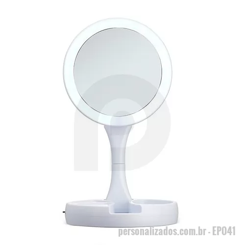Espelho personalizado - Espelho Dobrável com LED Recarregável é uma peça elegante e funcional que combina praticidade e estilo para atender às suas necessidades de cuidados pessoais. Este espelho é projetado para se adaptar ao seu estilo de vida agitado, proporcionando iluminação eficiente e a conveniência de ser dobrável e recarregável. Equipado com LEDs brilhantes e de baixo consumo de energia, o espelho oferece uma iluminação suave e natural para garantir uma visão nítida e detalhada, ideal para a aplicação de maquiagem, cuidados com a pele ou barbear. A opção de ajuste de intensidade luminosa permite personalizar a iluminação de acordo com as suas necessidades. Com três compartimentos na base para armazenamento de acessórios, espelho giratório e regulável, botão liga/desliga e botão para acionar a iluminação, com funcionamento à base de 4 pilhas AA ou via cabo USB. Acompanha antiderrapantes emborrachados. O espelho personalizado permite personalização com sua marca gravada em tampografia. Faça uma cotação