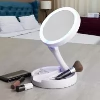 Espelho Dobrável com LED Recarregável e dupla face, material plástico. O espelho possui uma das faces ampliada 10x e do outro lado, espelho convencional 1x, iluminação LED dos dois lados, três compartimentos na base para armazenamento de acessórios, espelho giratório e regulável, botão liga/desliga e botão para acionar a iluminação, com funcionamento à base de 4 pilhas AA ou via cabo USB. Acompanha antiderrapantes emborrachados.