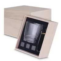 O Kit Drink inclui copo de vidro (200 ml), pegador de gelo em aço inox,  3 cubos de pedra-sabão reutilizáveis e caixa de madeira elegante.