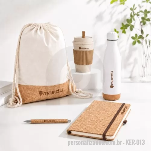 Kit Boas Vindas personalizado - Garrafa térmica: em aço inox de parede dupla isolada a vácuo, com tampa em aço inox e base em cortiça. Capacidade até 560 mL. Fornecida em caixa presente de papel kraft reciclado. Certificação EU Food Grade. Sacola: tipo mochila em 70% algodão reciclado e 30% poliéster reciclado (180 g/m²) com base em cortiça. Alças em algodão. 370 x 410 mm Caderno A5:  de capa dura em cortiça. Contém 160 páginas lisas cor marfim, em papel proveniente de gestão florestal sustentável, fita separadora, suporte para caneta esferográfica (não inclusa) e elástico para fecho do bloco. Copo:  em fibra de trigo livre de BPA, capacidade para até 450ml e tampa rosqueável com bocal. Acompanha mexedor e manga antiderrapante. Caneta: de cortiça com carga esferográfica azul 1.0mm e acionamento por clique. Clipe metálico, acionador e ponteira plástica.