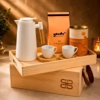 Kit café gourmet Cassetta Nero em caixa de madeira ecológica com tampa-bandeja. Contém 2 xícaras de porcelana de 170ml com pires de madeira, garrafa térmica retrô de 1000ml, café moído especial Clássico de 250g e lata de biscoitos amanteigados de 160g.