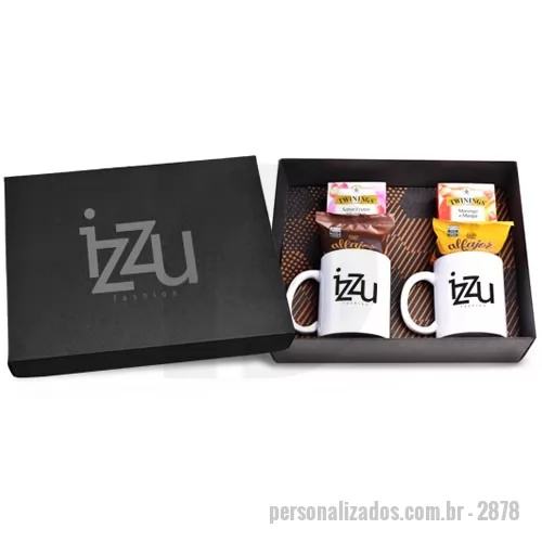 Kit chá personalizado - Kit de Chá composto por 2 caixas de chá importado da marca Twinings, marca inglesa de primeira escolha com 10 sachês com sabor de Frutas Silvestres e 10 sachês de Morango com Manga, 2 Alfajores de doce de leite ou chocolate de acordo com a disponibilidade e 2 canecas de cerâmica na cor branca. A personalização nas canecas e na tampa da caixa é em silk 1 cor. Os produtos são acondicionados em caixa de papel kraft preta com personalização silkscreen 1 cor. Formato da caixa 35,5 x 29 x 10,5 cm.