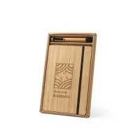 Conjunto de caderno A5 e esferográfica em bambu. O caderno de capa e contracapa em placa de bambu e lombada em poliéster 100% reciclado (100% rPET). Interior contém 96 folhas pautadas com papel reciclado. Suporte para esferográfica (inclusa) e elástico para fecho do caderno. Esferográfica em bambu e escrita em preto. Fornecido em caixa presente papel kraft reciclado. Caderno: 140 x 210 mm | Esferográfica: ø11 x 138 mm | Caixa: 160 x 255 x 18 mm