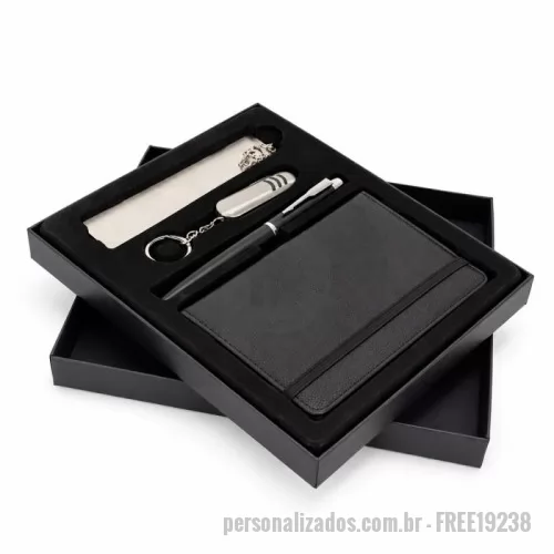 Kit executivo personalizado - Kit executivo composto por quatro itens: caderneta, caneta, canivete e marcador de página. A caderneta possui capa em poliuretano (PU), elástico para fechamento, marca-página em fita de cetim e aproximadamente 76 folhas marfim pautadas. A caneta metálica conta com tampa e carga esferográfica preta de 0,7mm. O canivete em inox apresenta três funções diferentes: lâmina de corte, lixa de unha e uma mini tesoura. O marcador de páginas metálico dispõe de chapa lisa personalizável nas duas faces. Acompanha caixa em papelão com berço removível em plástico de acabamento aveludado para acomodação dos itens do conjunto.
