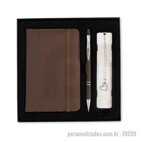 Kit executivo personalizado - Kit executivo personalizado composto por 3 peças: caderneta, caneta metálica e marcador de páginas. A caderneta possui capa em poliuretano (PU), elástico para fechamento, marca-página em fita de cetim e aproximadamente 76 folhas pautadas na cor marfim. A caneta metálica possui acabamento emborrachado, acionamento por clique, ponteira touch para telas sensíveis ao toque e carga azul de 1,0 mm. O marcador de páginas metálico possui chapa lisa personalizável nas duas faces. Acompanha caixa presenteável em papelão com berço interno de acabamento aveludado. Ideal para brindes corporativos, presentes executivos, kits de onboarding, eventos, convenções, clientes e colaboradores. Pode ser personalizado com logotipo ou identidade visual da empresa.