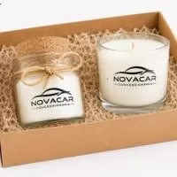 Kit com 2 velas aromatizadas no copo de vidro personalizado sendo um com tampa de cortiça, na caixa kraft com rami e tag