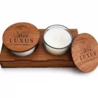 Duas vela aromatizadas com tampa e suporte base em madeira. Prontas para presentear seus clientes com elegância e deixando a marca da sua empresa presente.