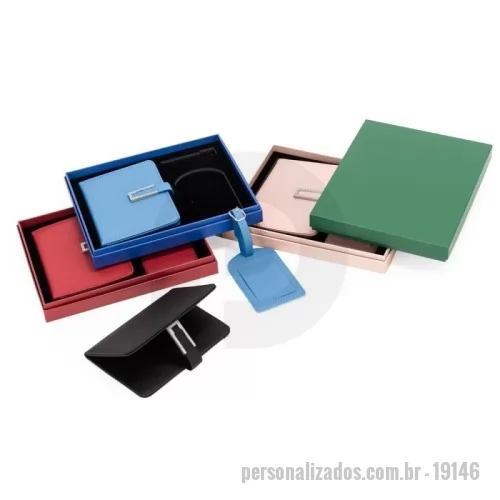 Kit viagem personalizado - Kit de viagem composto por dois itens: porta-passaporte e tag identificadora de bagagem, ambos em poliuretano (PU). O porta-passaporte possui fechamento magnético e fivela metálica, dois bolsos internos, sendo um deles com quatro compartimentos para cartões, além de dois bolsos menores para cartões SIM. A tag identificadora apresenta aba para proteger o visor plástico e um cartão interno dupla face em papel cartão no tamanho 5,5 cm x 8,5 cm para o preenchimento de dados pessoais, além de alça lateral em PU com fivela metálica. Acompanha caixa em papelão com berço fixo em espuma de EVA com acabamento aveludado para guardar os itens do conjunto. *Diversas cores.