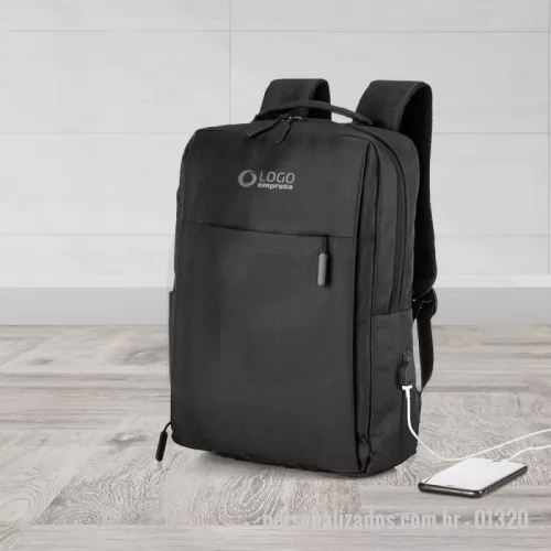 Mochila para notebook personalizada - Descrição: Mochila de nylon 20 litros com três compartimentos, sendo o principal com bolso para notebook 15,6. Com divisórias internas para acessórios, a mochila possui bolso lateral e suporte externo usb.  Altura :  42 cm  Largura :  30 cm  Profundidade :  17 cm  Medidas aproximadas para gravação (CxL):  23 cm x 10 cm