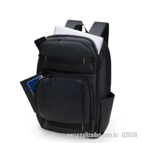 Mochila personalizada - Mochila com capacidade máxima de 23 litros. Confeccionada em poliuretano (PU) impermeável, contém estrutura interna em espuma acolchoada. Possui três compartimentos em tamanhos diferentes, incluindo um com divisória interna para notebooks de até 15,6 polegadas e tira elástica com velcro para fixação, além de dois bolsos laterais em tela de malha com elástico. Dispõe de alça de mão, engate para malas e revestimento acolchoado em tecido mesh na região das costas e nas alças de ombro.