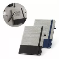 Caderno A5 com capa dura em palha e algodão canvas. Contém 96 folhas pautadas, fita separadora, elástico e suporte para esferográfica (não inclusa). 150 x 210 mm