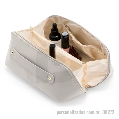 Nécessaire personalizado - Nécessaire em poliuretano (PU) impermeável com abertura em 180 graus inspirada no formato de concha. O compartimento interno conta com dois bolsos laterais abertos e um, localizado na parte central, com fechamento em zíper. Possui alça para transporte.