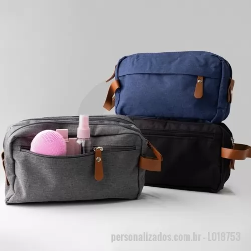 Nécessaire personalizado - Nécessaire confeccionada em poliéster, com detalhes em couro sintético. Possui três compartimentos com zíper. Na parte interna, contém 5 bolsos, sendo dois de tela, e alça para transporte.  Altura :  14,5 cm  Largura :  25 cm  Profundidade :  10 cm  Comprimento :  Alça: 21 cm
