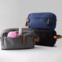 Nécessaire confeccionada em poliéster, com detalhes em couro sintético. Possui três compartimentos com zíper. Na parte interna, contém 5 bolsos, sendo dois de tela, e alça para transporte.