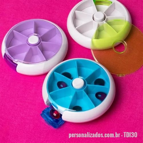 Porta comprimido personalizada - Porta-comprimidos em plástico com design compacto. Possui sete divisórias e um botão de acionamento que gira um compartimento a cada clique, permitindo o acesso ao conteúdo por meio de uma abertura lateral.