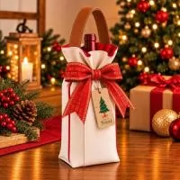 Porta vinho 750ml confeccionado em lona de algodão cru, com forro vermelho, alça reforçada em couro sintético caramelo, acabamento em viés, laço natalino decorativo e tag personalizada com tema de natal.  Medidas: Comprimento: 15 cm Altura: 40 cm Largura: 10 cm  Pedido mínimo de 100 unidades
