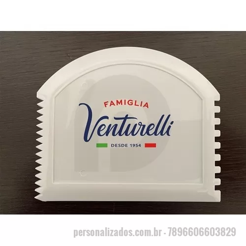 Raspador Alimentício personalizado - Peça moldada pelo processo de injeção para ser  utilizada em 4 funções:  a)	para raspagem de assadeiras lisas (lado plano),  b)	raspagem de assadeiras com alojamentos circulares p/ pães no processo industrial,  c)	decorar laterais de bolos com perfil quadrado e d)	decorar laterais de bolos com perfil triangular.  O Raspador Spland é produzido com materiais plásticos atóxicos de 1ª linha isentos de Ftalatos e Metais Pesados para uso em contato com alimentos. Os pigmentos utilizados são também atóxicos próprios p/ uso em contato com alimentos. O produto é muito utilizado como brinde nos setores de panificação e de confeitaria e pode ser personalizado com o logo do cliente. A personalização é realizada com utilização de “Promotor de Aderência” para que a impressão não se solte.  É realizada pelo processo de Tampografia também com tintas atóxicas livres de metais pesados. O produto é reciclável em processos convencionais. A matéria prima normalmente usada é o Polipropileno –PP mas pode ser
