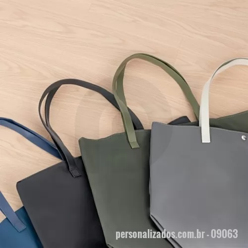 Sacola de couro ou sintético personalizada - Sacola em Couro Sintético Personalizada – Fabricação Própria  A Sacola em Couro Sintético Personalizada é um produto sofisticado, resistente e de alto valor agregado, ideal para empresas que desejam transmitir elegância e profissionalismo em suas ações promocionais. Com acabamento premium, é uma excelente opção para brindes corporativos de impacto e uso diário.  Confeccionada em couro sintético à base de PVC, a sacola oferece durabilidade, fácil limpeza e aparência refinada. Possui alças com costura externa reforçada e fechamento com botões magnéticos metálicos, garantindo praticidade e segurança no uso.  Seu interior conta com revestimento em poliéster e bolso interno compacto com zíper, proporcionando organização e funcionalidade para transportar itens pessoais, materiais de trabalho ou brindes.  A EV Brindes, com fábrica própria, desenvolve sacolas personalizadas em diversos materiais, cores e tamanhos, permitindo total personalização de acordo com a identidade visual da sua marca. 