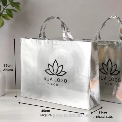Sacola de TNT metalizado personalizada - Descrição: Sacola TNT metalizada 110g/m² com botão. Confeccionado em TNT com revestimento plástico laminado, parte superior possui botão plástico para fecho.  Altura :  35 cm  Largura :  45,5 cm  Profundidade :  13,5 cm