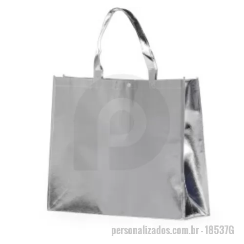 Sacola de TNT personalizada - Apresentamos a Sacola TNT Metalizada G Personalizada, a solução perfeita para quem busca praticidade, estilo e um toque de brilho em um único produto. Ideal para compras, feiras, eventos ou como brinde promocional, essa sacola é a escolha moderna e versátil para quem se preocupa com a imagem da sua marca.  Características TNT metalizado: Confeccionada em TNT com revestimento laminado, que confere um visual moderno e sofisticado à sacola, além de maior resistência e durabilidade. Tamanho generoso: Com dimensões de 40,5x50x14cm, oferece amplo espaço para carregar compras, livros, documentos, brindes e outros objetos do dia a dia. Fechamento seguro: A parte superior possui um botão plástico que garante o fechamento da sacola, evitando que os objetos caiam ou se percam. Personalização exclusiva: Adicione sua marca, logo, arte ou mensagem e transforme a sacola em um brinde único e memorável para seus clientes, colaboradores ou eventos. Vantagens Estilo e modernidade: O acabamento metalizado