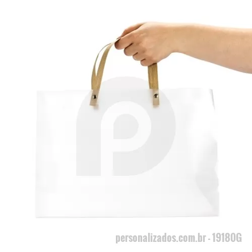 Sacola personalizada - Sacola confeccionada em plástico polipropileno (PP) de acabamento fosco, fundo com revestimento interno em papelão e alças em kraft fixadas por botões metálicos.