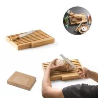 Tábua para pão em bambu com faca em aço inox. Grelha removível para fácil remoção de migalhas. Fornecido em caixa presente de papel kraft reciclado. Certificação EU Food Grade. A cor e o resultado da impressão nos materiais naturais pode variar entre