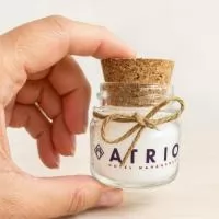 Vela aromatizada no pote de vidro com tampa de cortiça e enfeite de rami e laço.