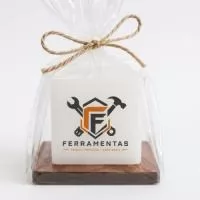 Vela aromática maciça  personalização com a  sua logomarca, com uma base de madeira e embalada no saquinho transparente com laço rami . Um brinde elegante e com presença.